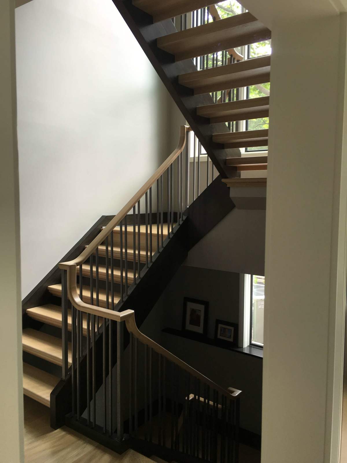 Open wood staircase with dark metal railing