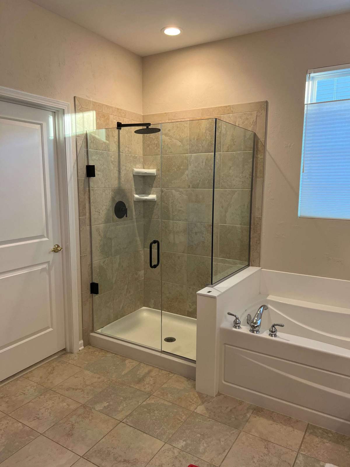 Remodeled shower with frameless glass and tiled niche