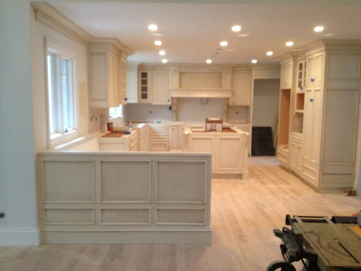 White kitchen cabinetry and island during installation