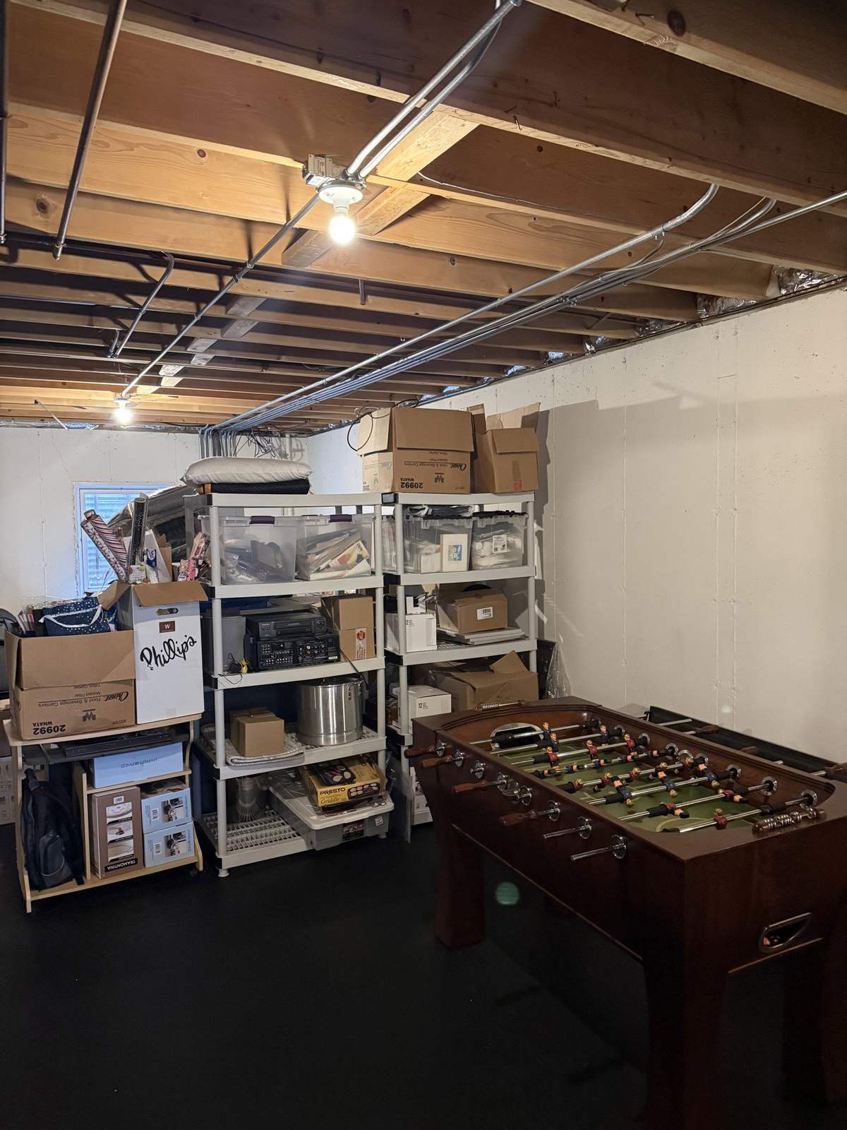 Unfinished basement with exposed joists and storage