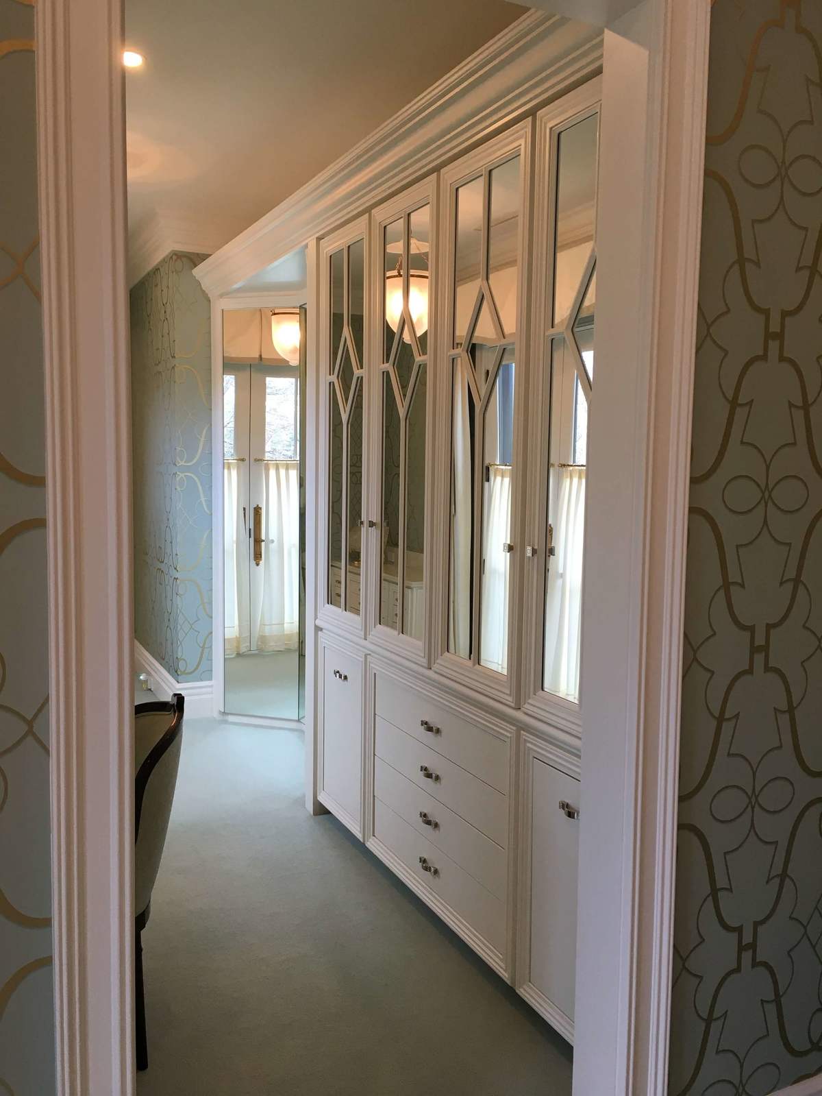 Hallway with built-in cabinets and mirrored doors