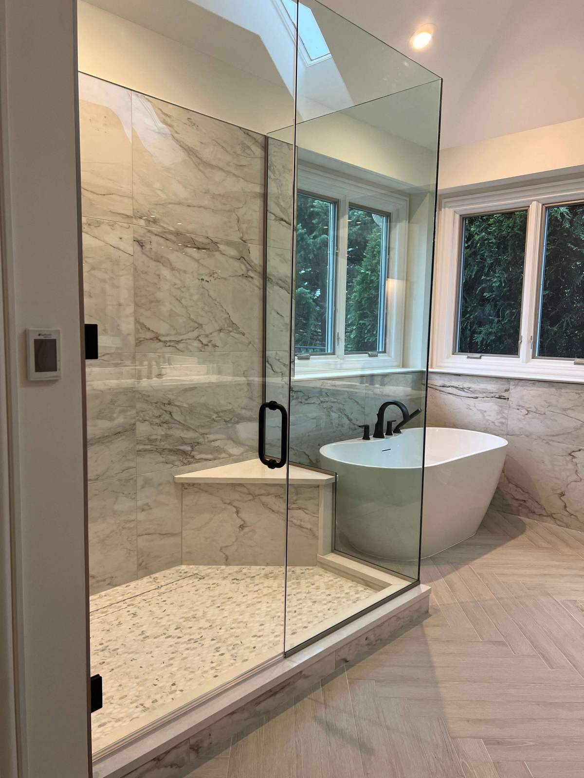 Remodeled bathroom with freestanding tub and glass shower