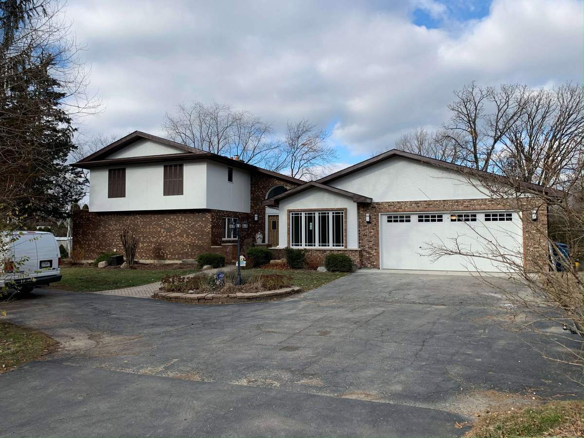 Updated house exterior with lighter siding and dark gable trim