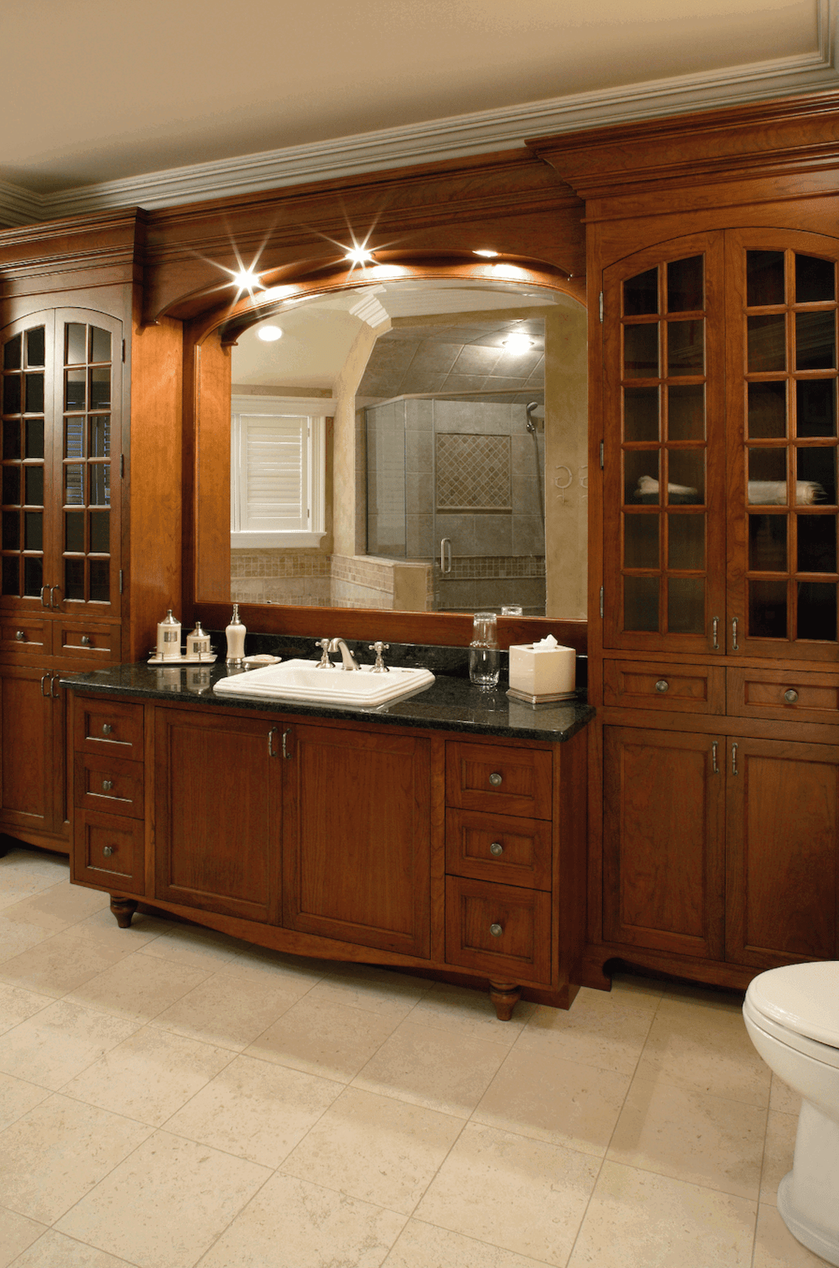 Wood bathroom vanity with glass-front storage cabinets
