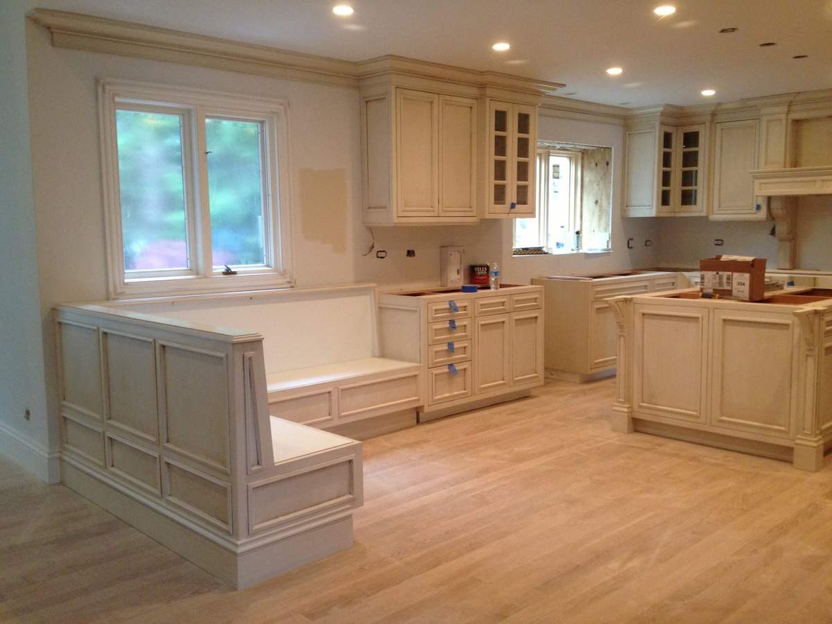 White kitchen cabinetry and island during a renovation