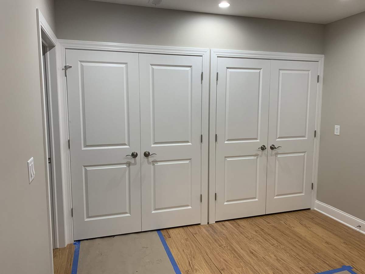 Finished basement storage with white double doors
