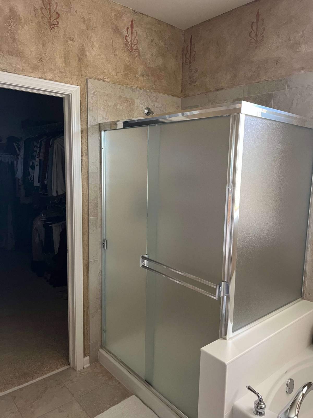 Shower before remodeling with framed glass enclosure