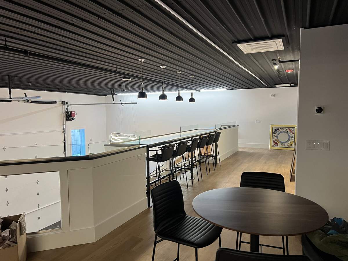 Long bar with stools beside recreation room seating