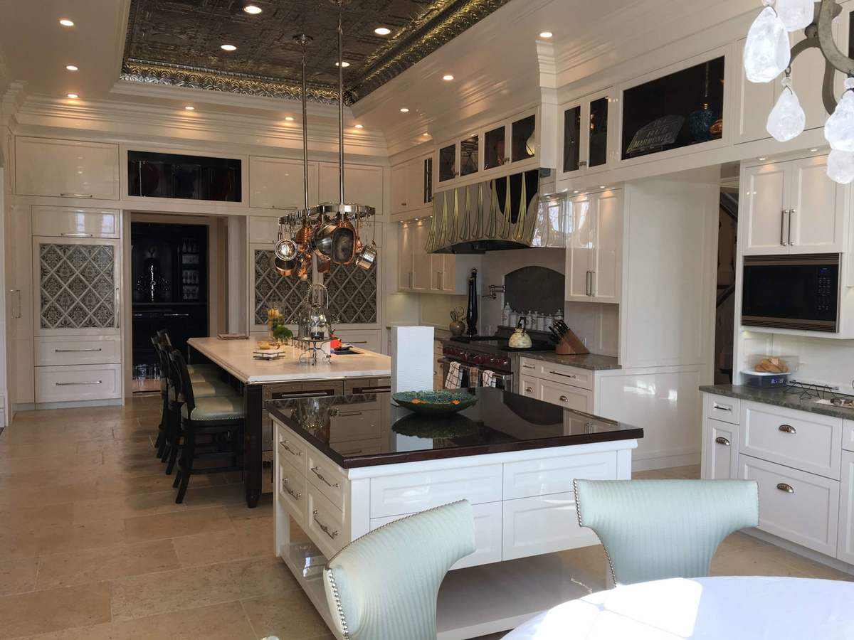 White kitchen cabinets with dark countertops and ceiling beams