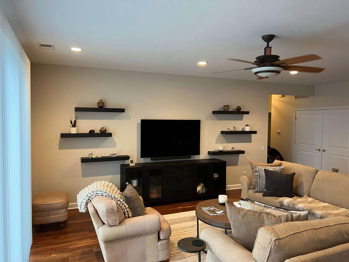 Remodeled living room with light walls and floating shelves