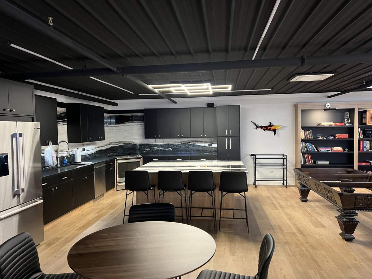 Recreation room kitchenette with dark exposed ceiling