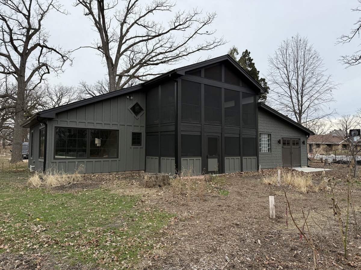 Renovated building with dark siding and screened porch