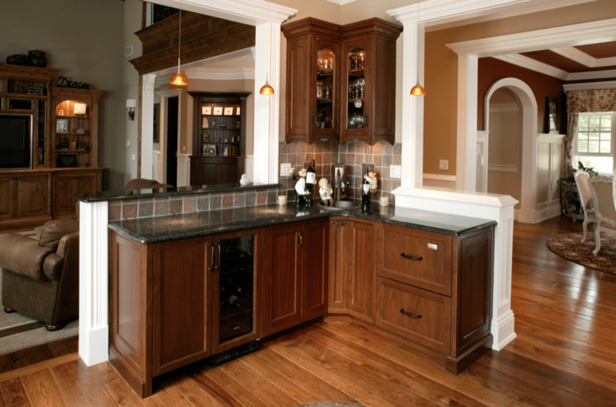 Wood wet bar with stone countertop and glass cabinets