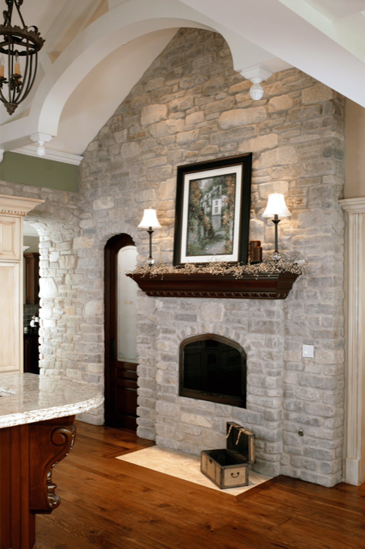 Tall stone fireplace with wood mantel